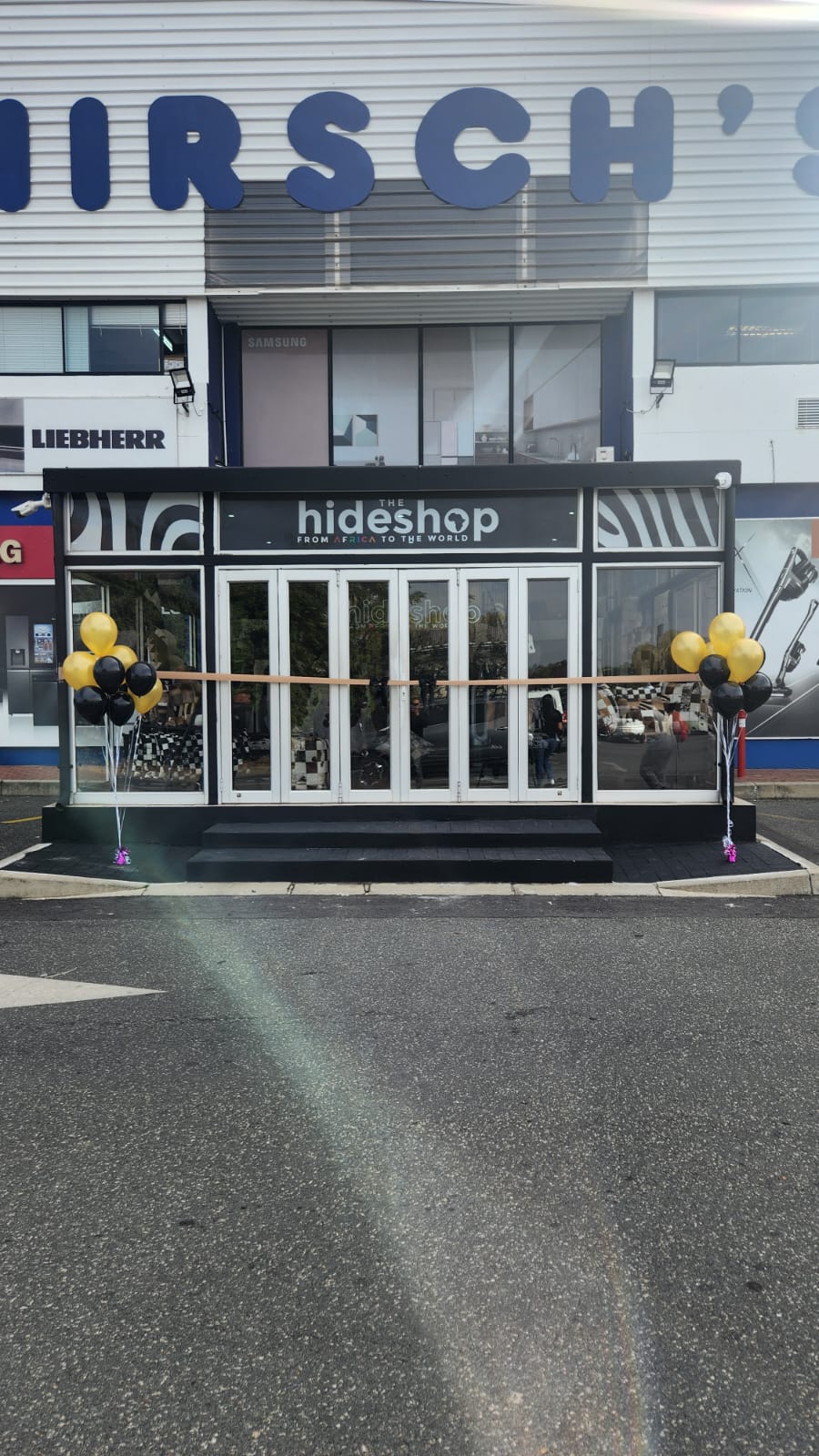 Storefront with 'hideshop' branding and balloons outside
