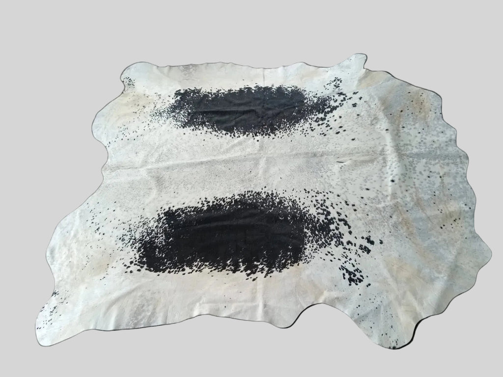 Cowhide rug with black spots on a white background