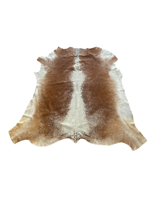 Brown and white cowhide rug on a white background
