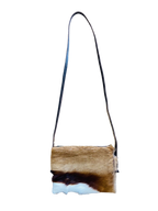 Crossbody bag with a natural cowhide pattern on a white background