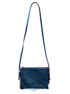 Blue leather crossbody bag with a strap on a white background