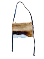 Brown and white Springbok hide bag with black strap on a white background