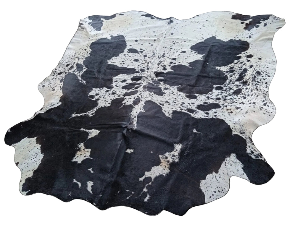 Black and white cowhide rug on a black background