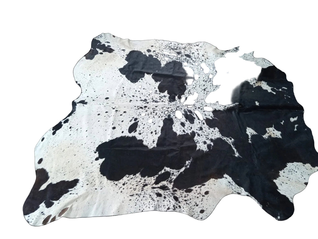Black and white cowhide rug on a black background