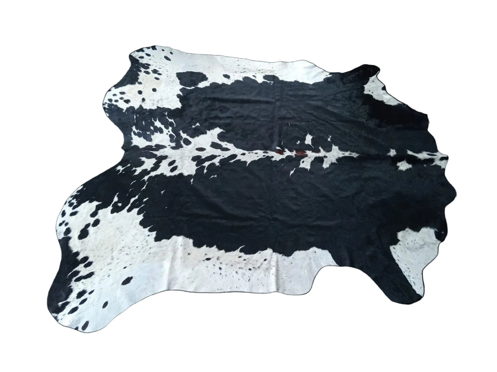Black and white cowhide rug on a black background