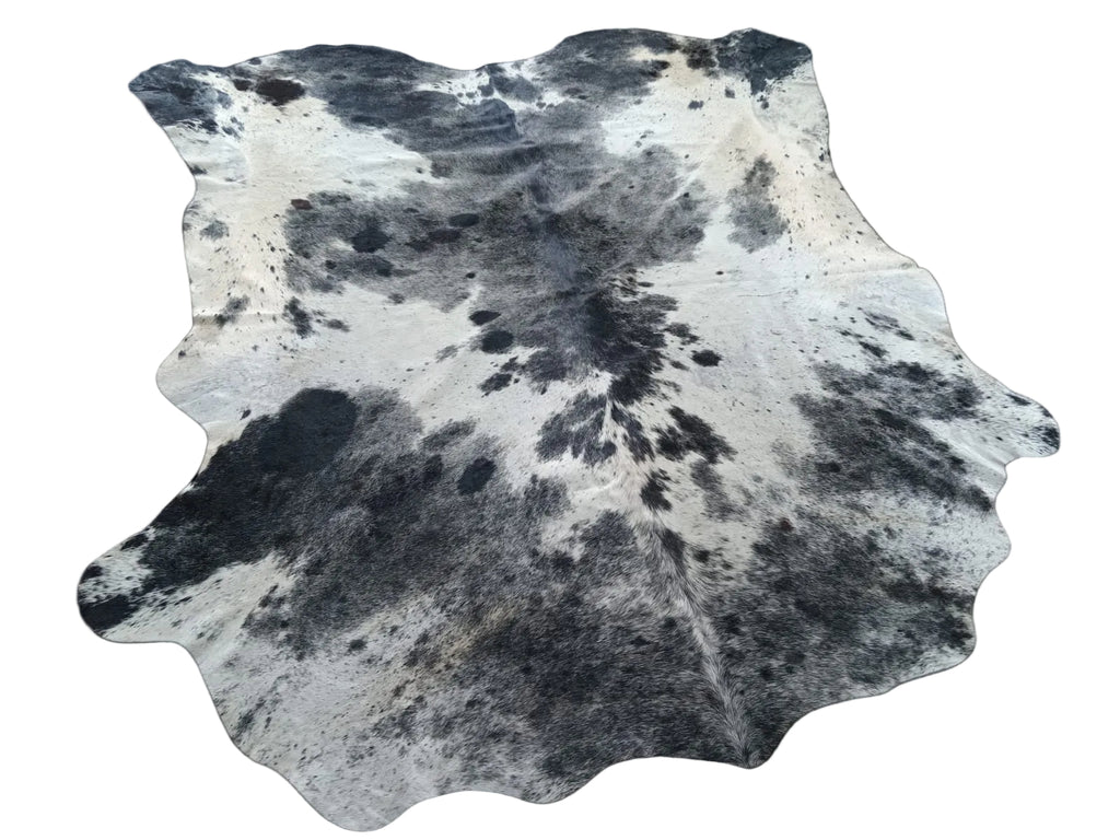 Cowhide rug with black and white pattern on a plain background