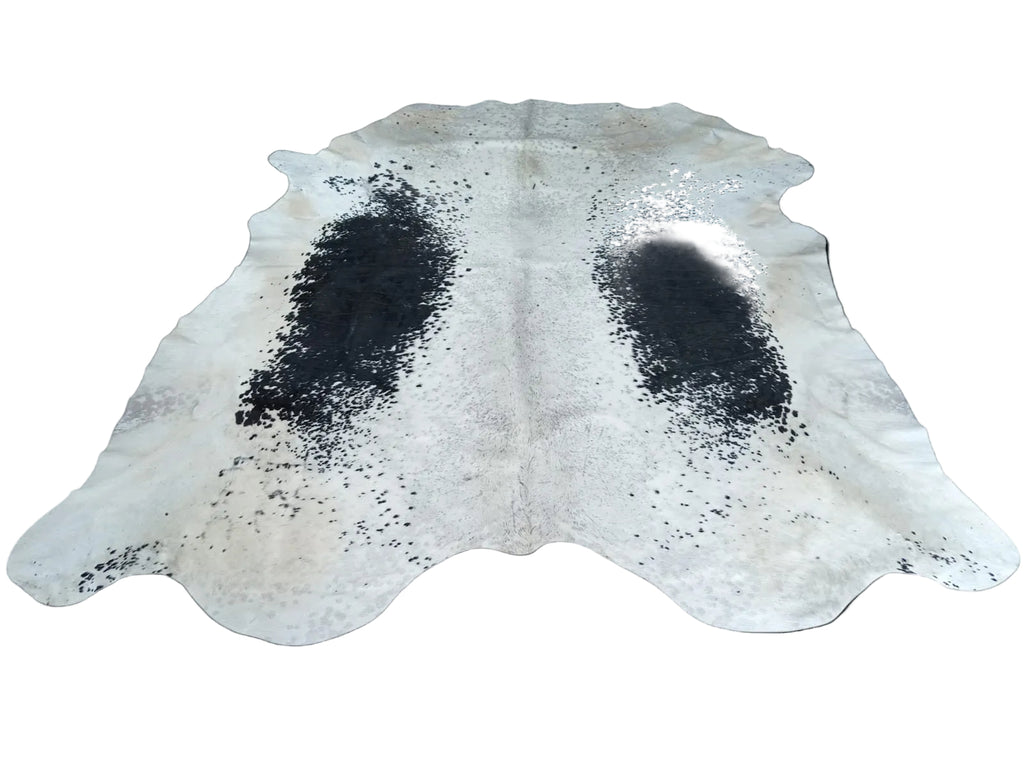 Cowhide rug with black spots on a white background